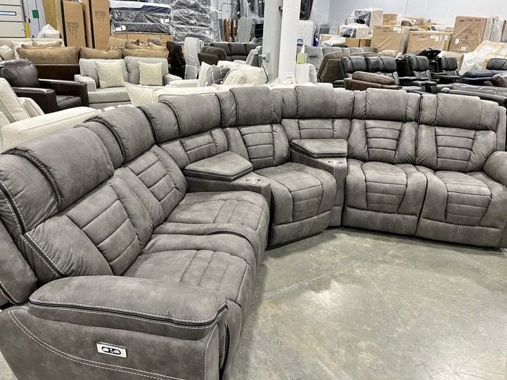 Large grey reclining sectional sofa in showroom